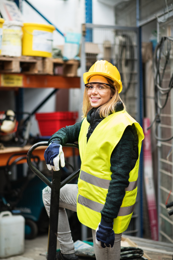 Beautiful young female worker in a warehouse.