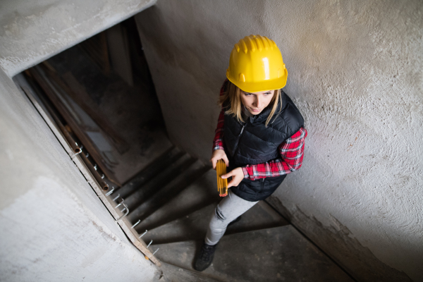 Female worker on the construction site. Beautiful young woman working on the building site.