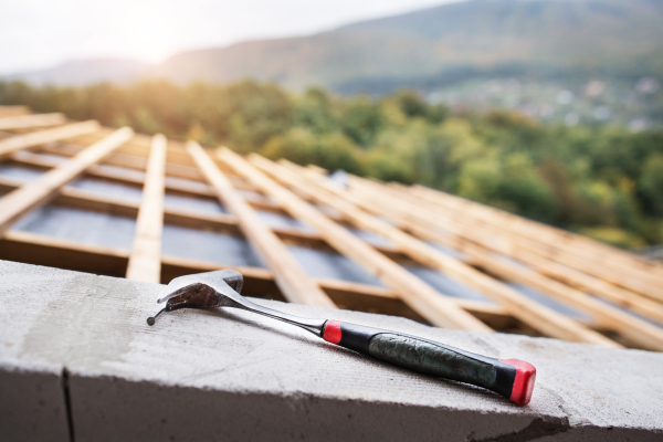 Hammer on the roof on the construction site. House construction.