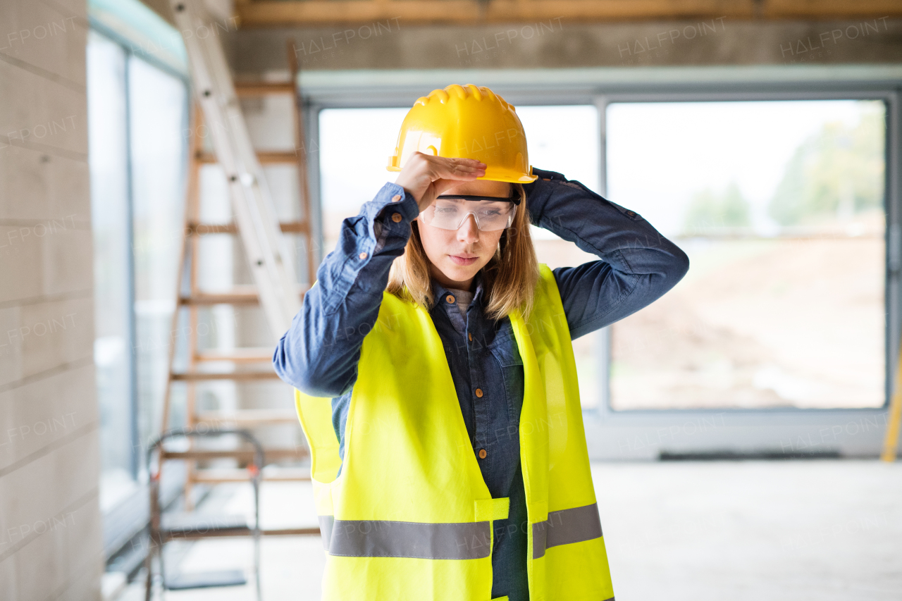 Female worker on the construction site. Beautiful young woman building a house.