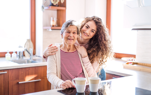 A teenage girl with grandmother at home. Family and generations concept.