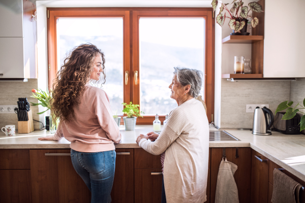 A teenage girl with grandmother at home. Family and generations concept.