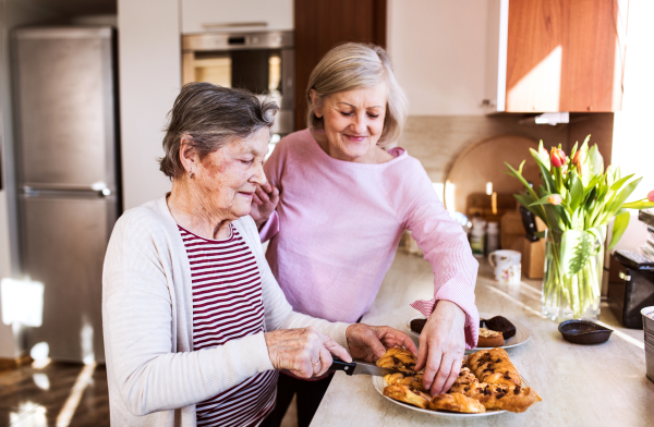 Two senior women preparing food in the kitchen. Family and generations concept.