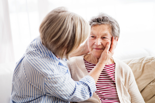 Two senior women at home, hugging. Family and generations concept.