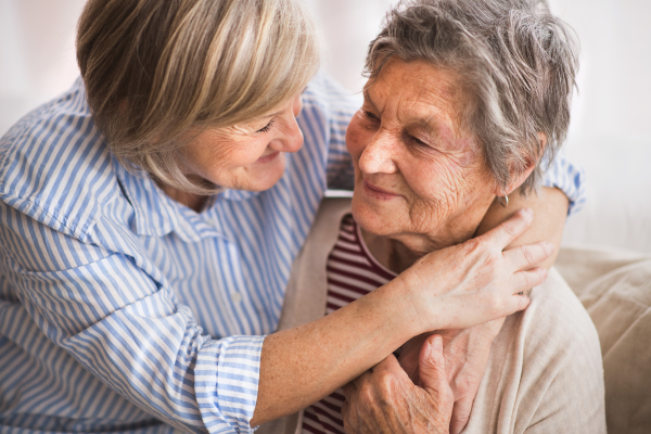 Two senior women at home, hugging. Family and generations concept.