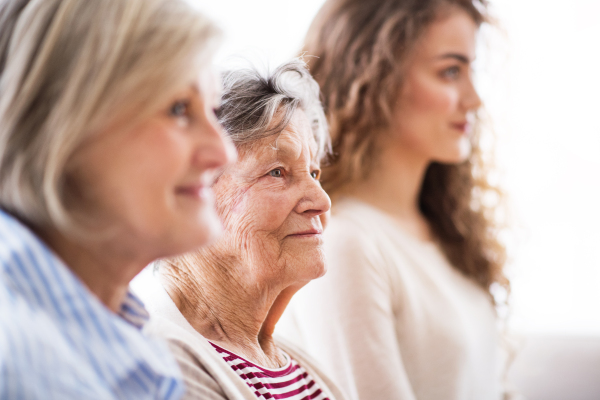 A teenage girl with her mother and grandmother at home. Family and generations concept.