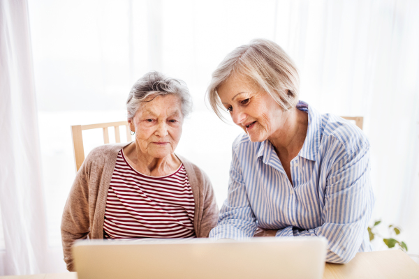 Senior woman with her mother with laptop at home. Family and generations concept.