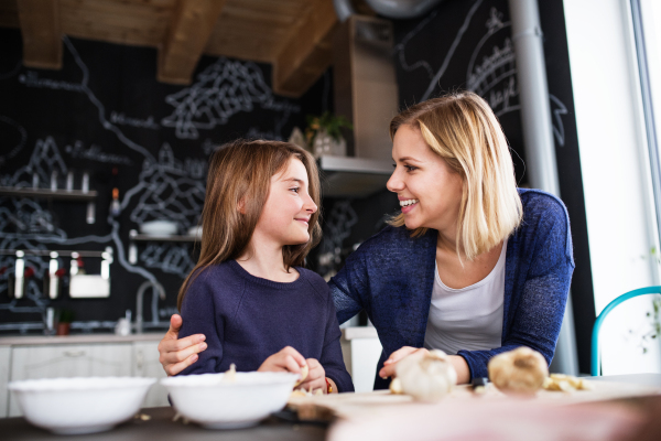 A small girl with her mother at home, cooking. Family and generations concept.