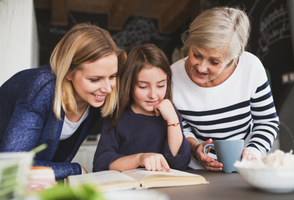 A small girl with her mother and grandmother at home. Family and generations concept.