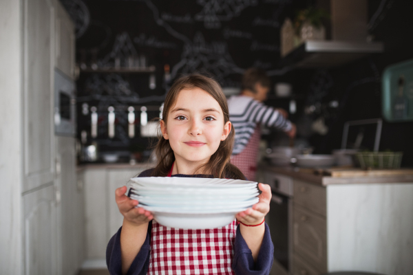 A small girl with grandmother helping in the kitchen. Family and generations concept.