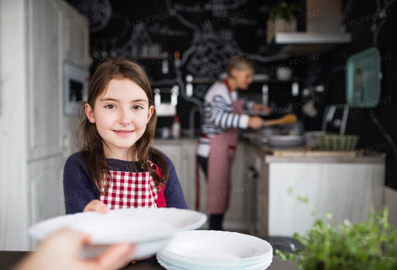 A small girl with her mother and grandmother at home, cooking. Family and generations concept.