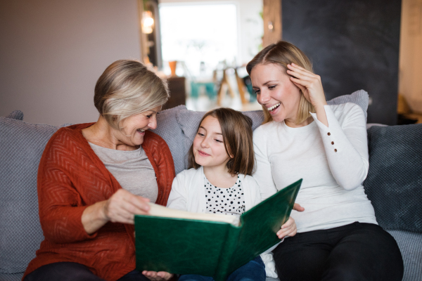 A small girl with her mother and grandmother at home. Family and generations concept.