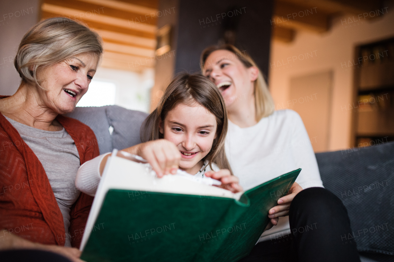 A small girl with her mother and grandmother at home. Family and generations concept.