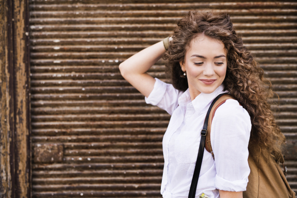 Beautiful young teenage girl with backpack in the old town.