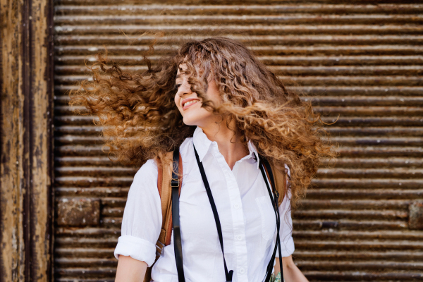 Beautiful young teenage girl with backpack in the old town.