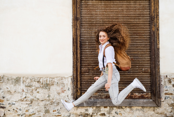 Beautiful young tourist with backpack in the old town.