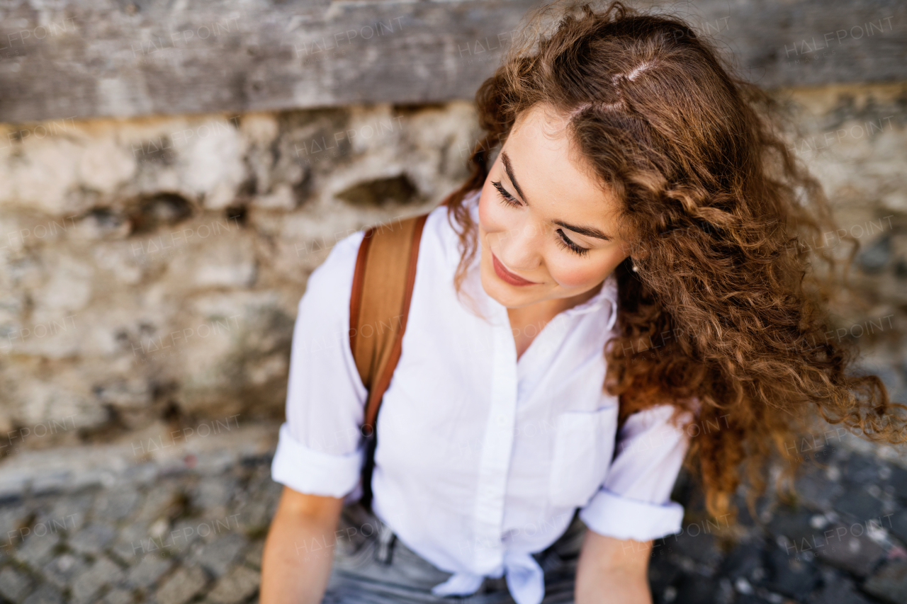 Beautiful young teenage girl with backpack in the old town.