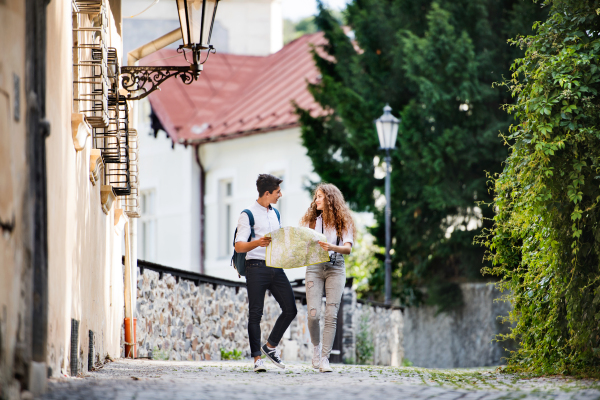 Two beautiful young tourists with map in the old town