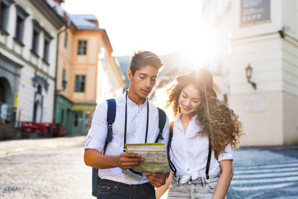 Two beautiful young tourists with map and camera in the old town