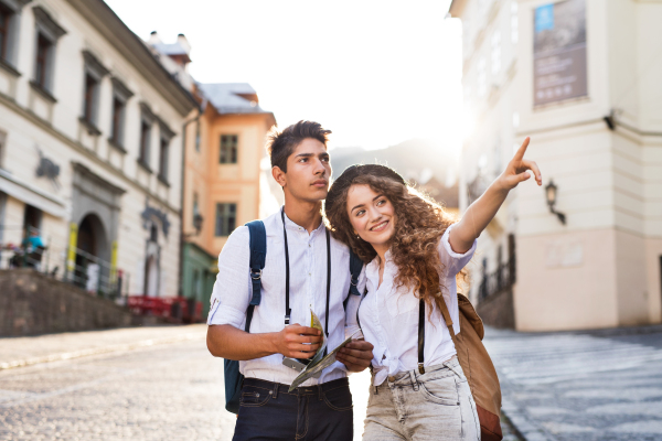 Two beautiful young tourists with map and camera in the old town