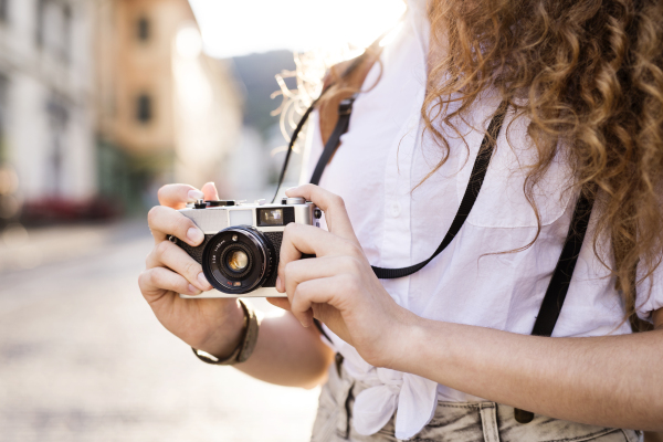 Unrecognizable young tourist with camera in the old town.