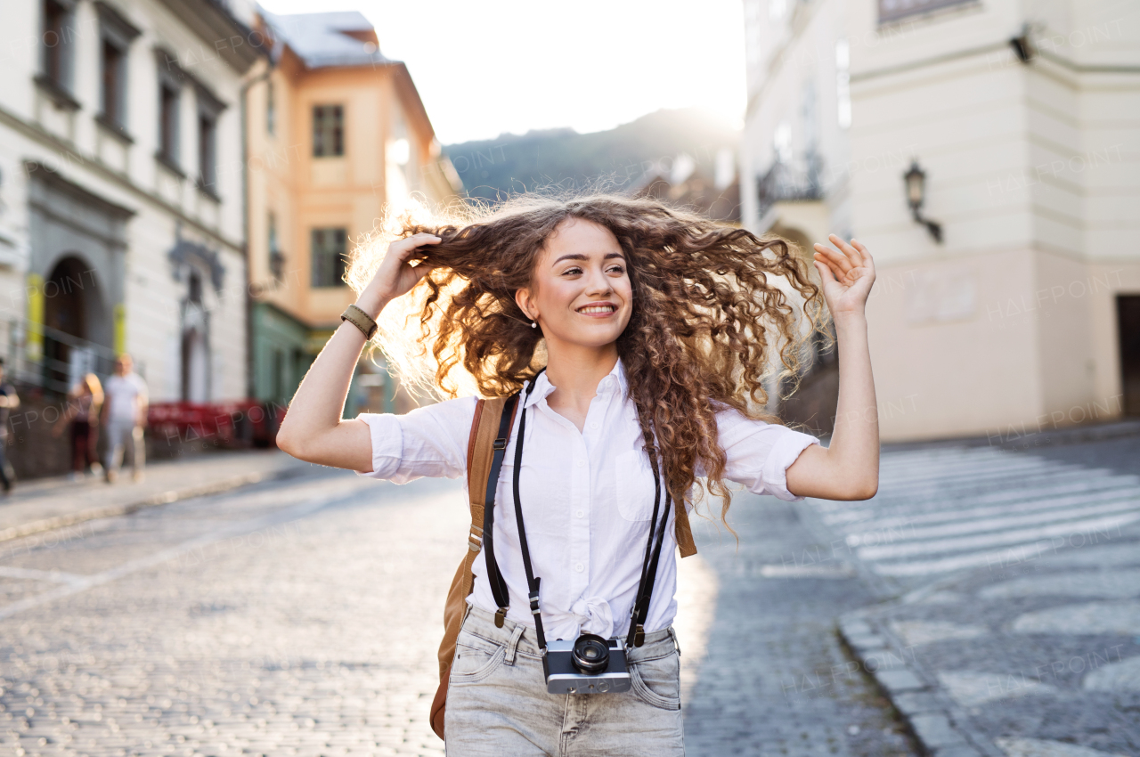 Beautiful young tourist with camera in the old town