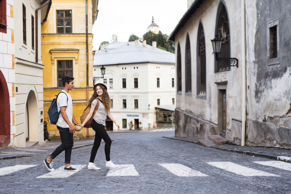 Two beautiful young tourists crossing the road in the old town.