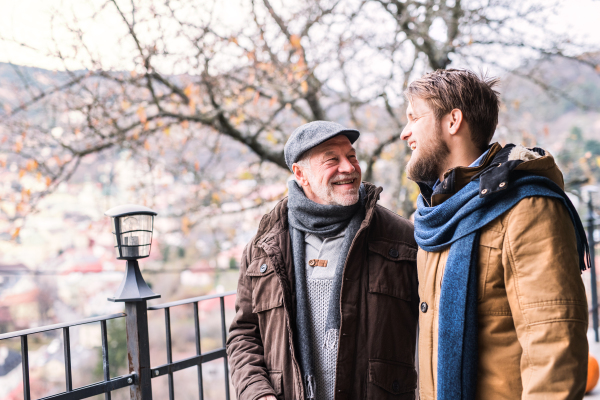 Senior father and his young son on a walk in town.