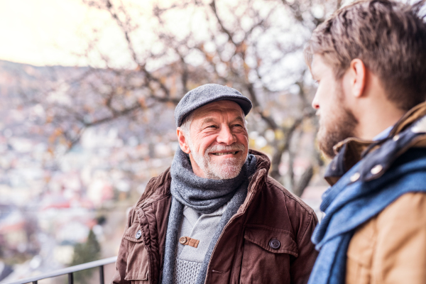 Senior father and his young son on a walk in town.