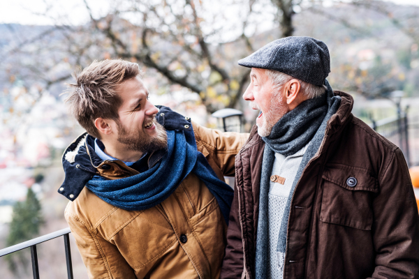 Senior father and his young son on a walk in town, having fun.