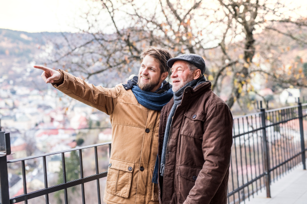 Senior father and his young son on a walk in town.