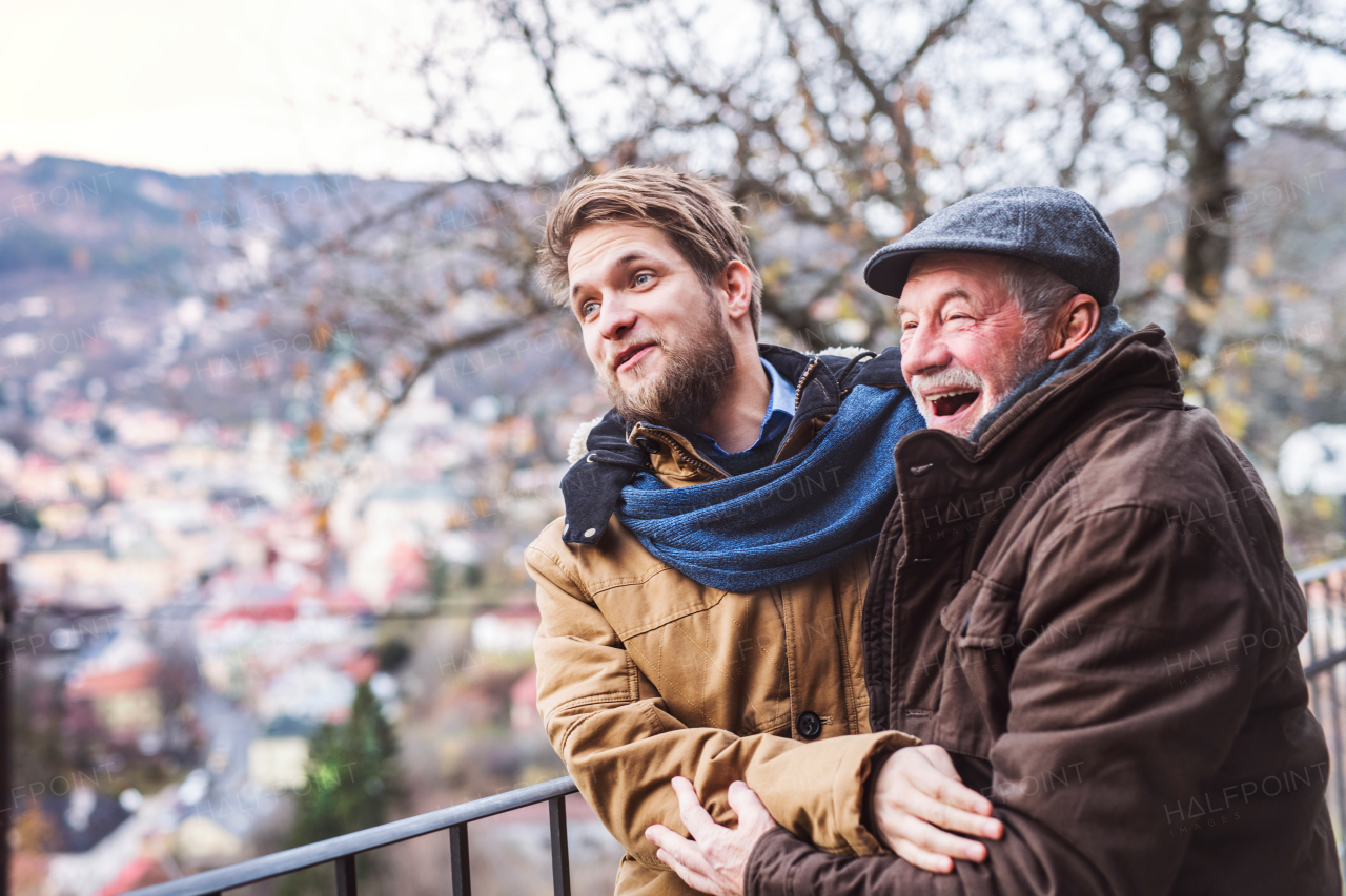 Senior father and his young son on a walk in town, having fun.