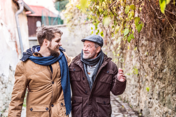 Senior father and his young son on a walk in town.