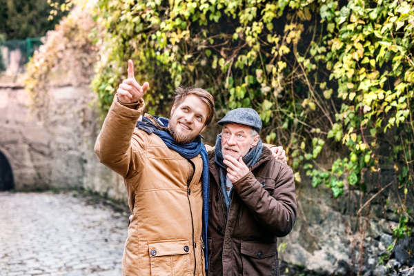 Senior father and his young son on a walk in town.