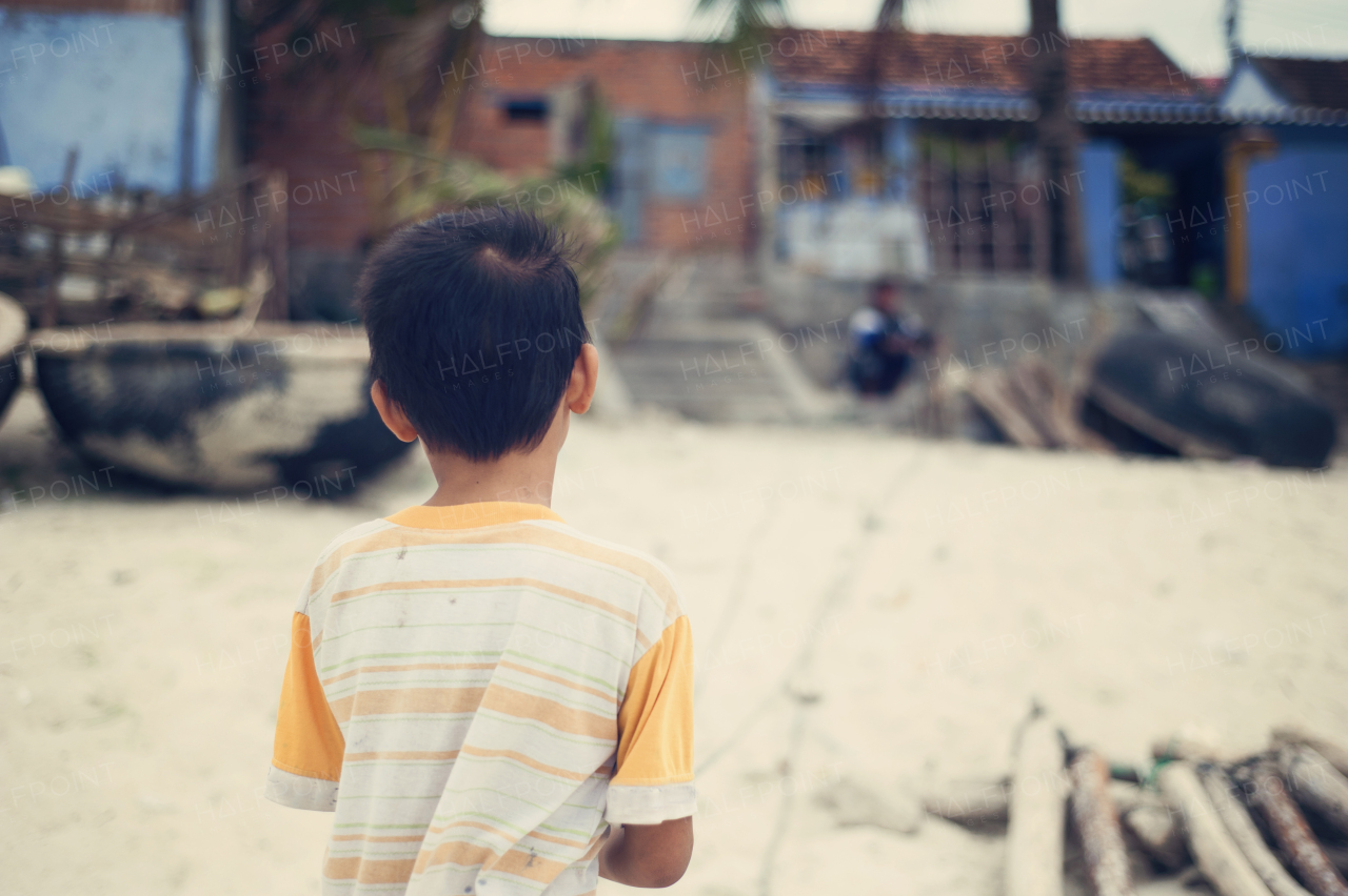 Little vietnamese boy outside his house on a beach