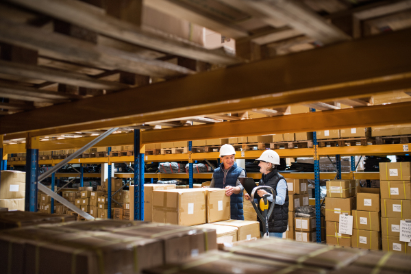 Senior woman and man managers or supervisors working together in a warehouse.