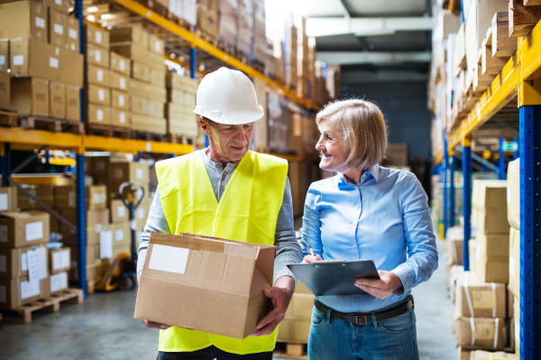 Senior woman manager and a man worker working together in a warehouse.