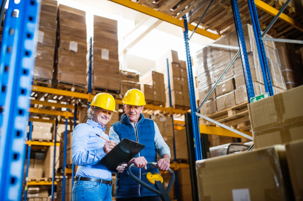 Senior woman manager and a man worker working together in a warehouse.