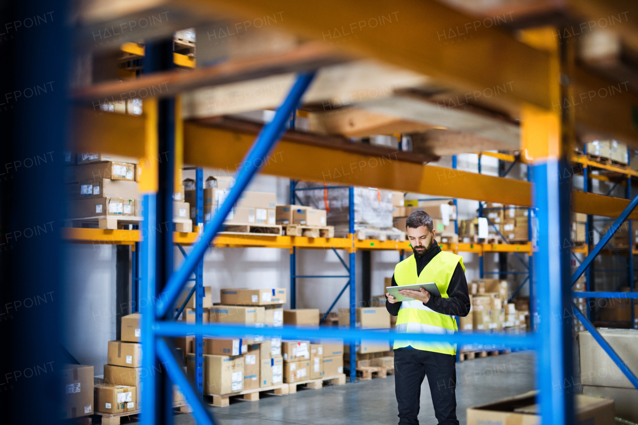 Portrait of a young male warehouse worker with tablet.