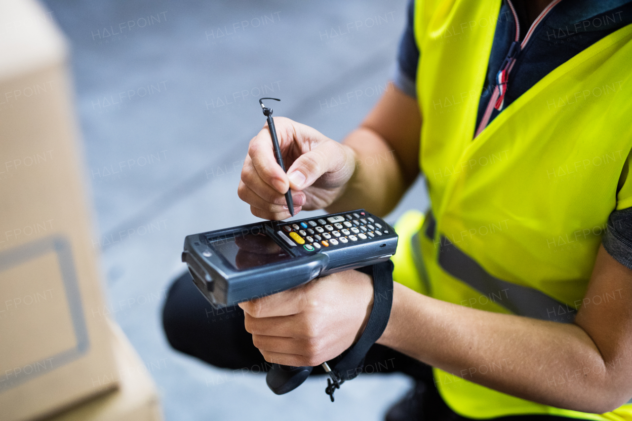 Unrecognizable male warehouse worker with barcode scanner.