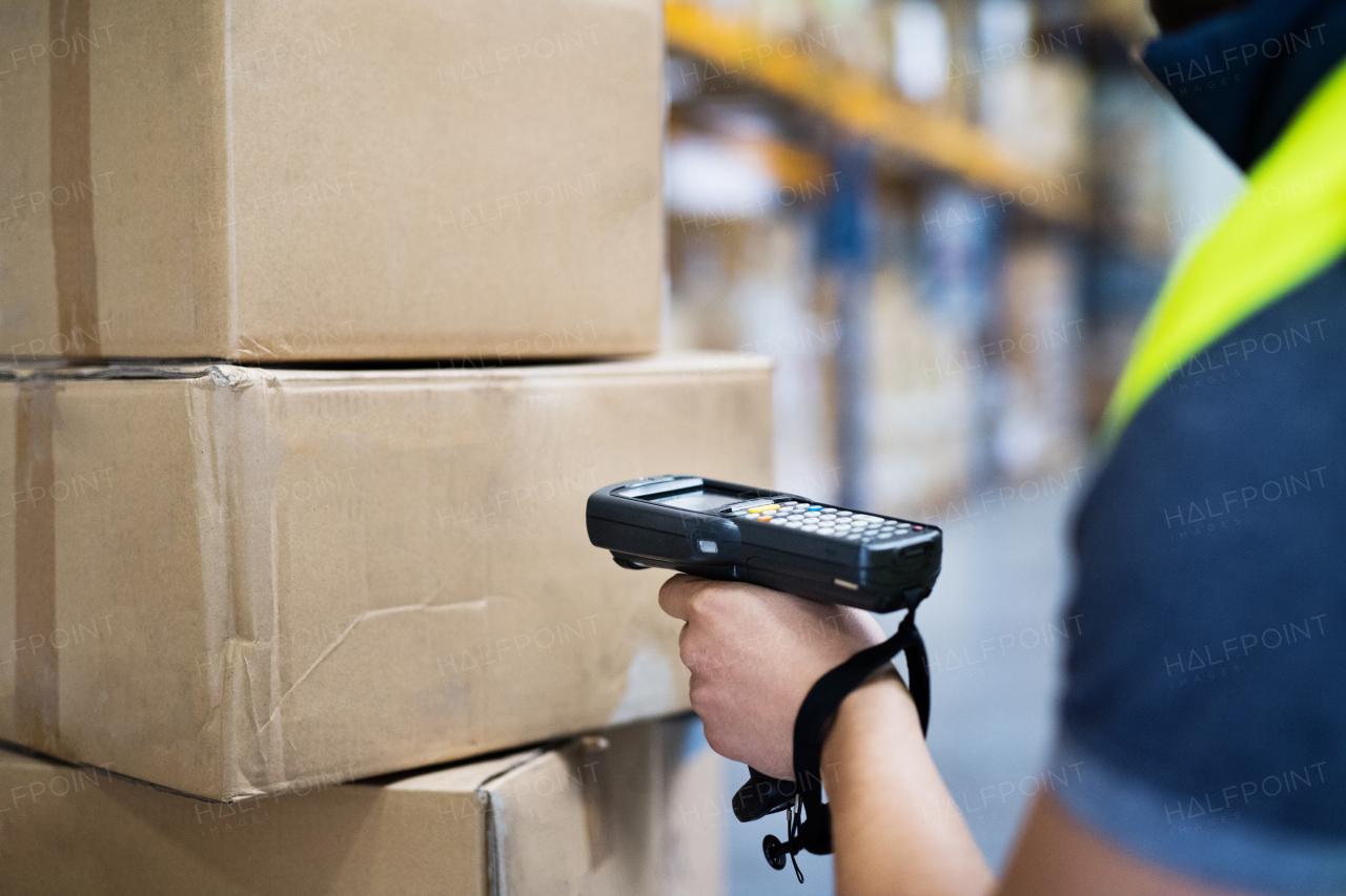 Unrecognizable male warehouse worker with barcode scanner.