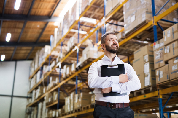 Portrait of a male warehouse worker or a supervisor holding notes.