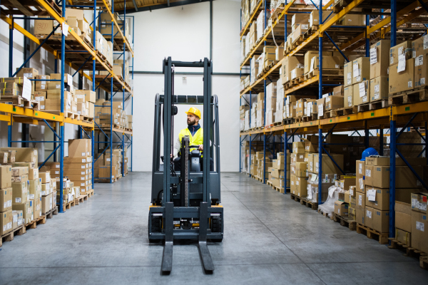 Man forklift driver working in a warehouse.