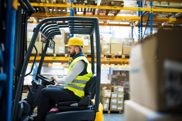 Man forklift driver working in a warehouse.