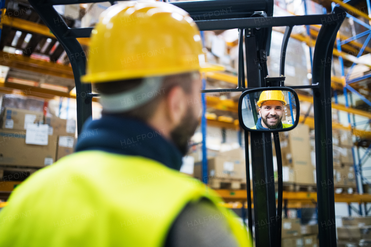 Man forklift driver working in a warehouse.