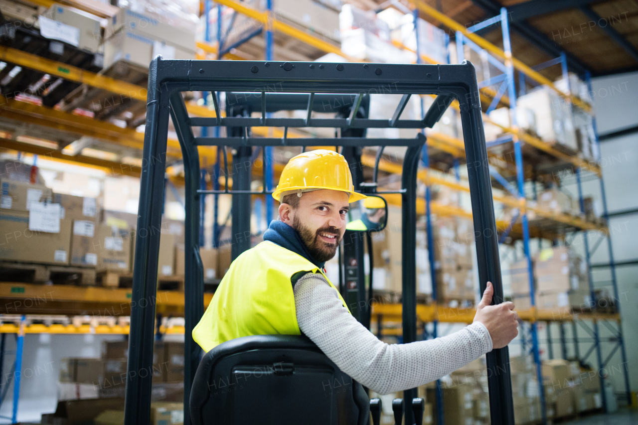 Man forklift driver working in a warehouse.