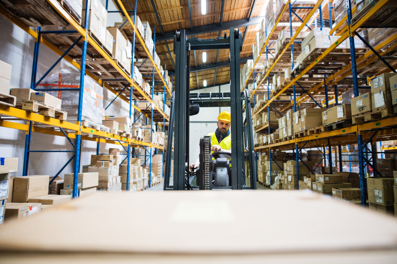 Man forklift driver working in a warehouse.