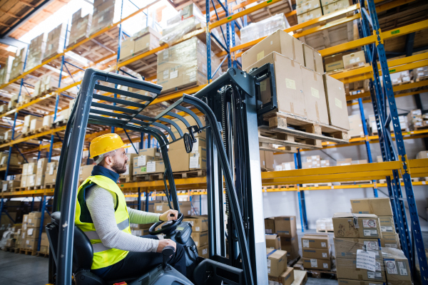 Man forklift driver working in a warehouse.