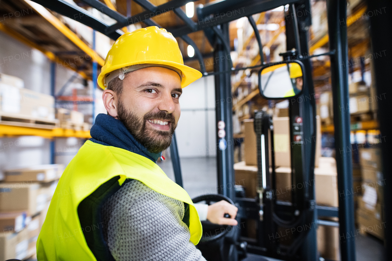 Man forklift driver working in a warehouse.