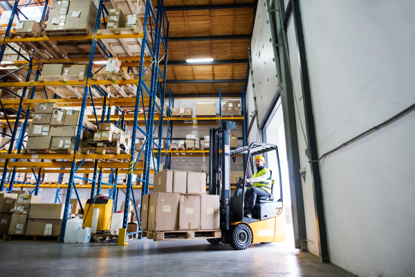 Man forklift driver working in a warehouse.